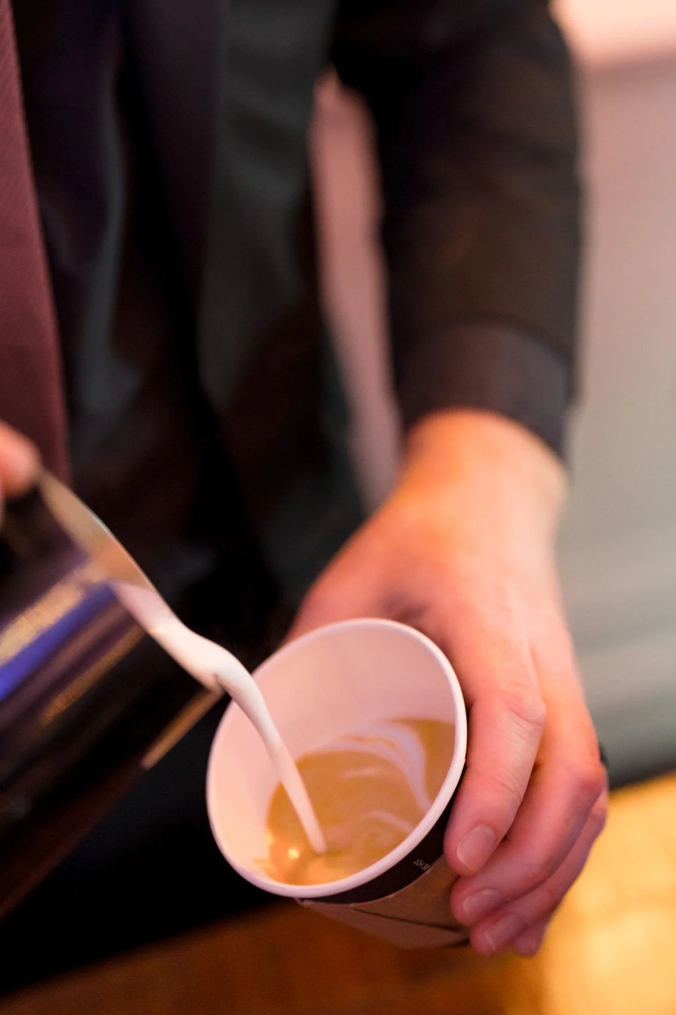 Barista pouring latte art late in the evening at a New Year's Eve gala