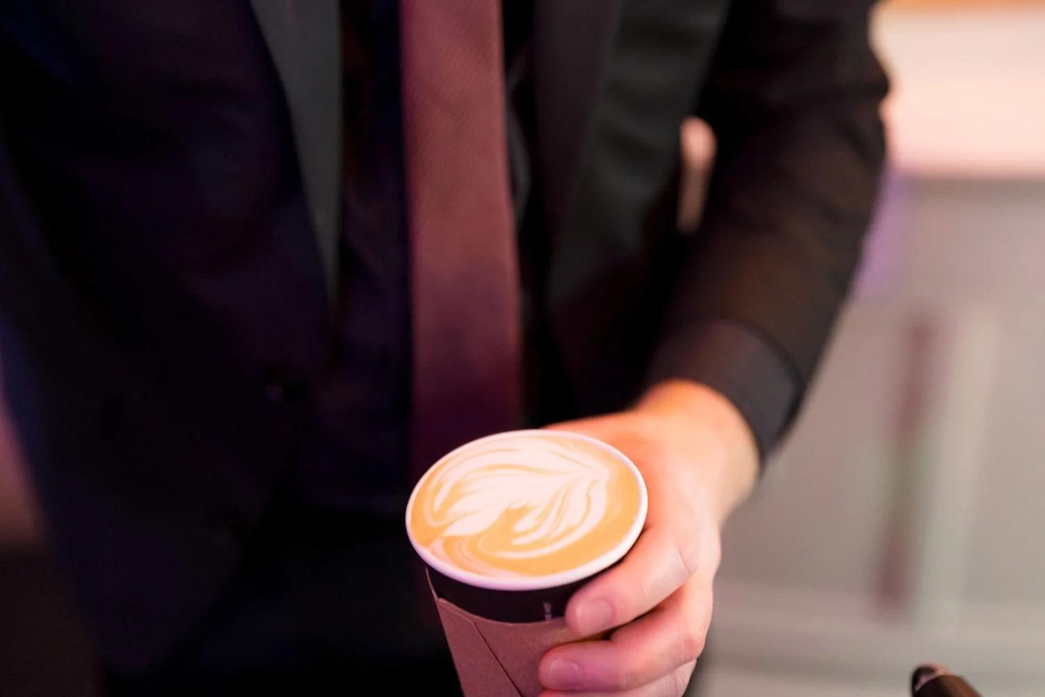 Latte with rosetta latte art in a black and white cup at a New Year's Eve gala