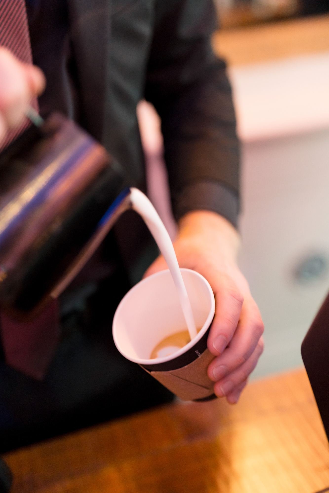 Barista pouring steamed milk into a latte at a New Year's Eve gala