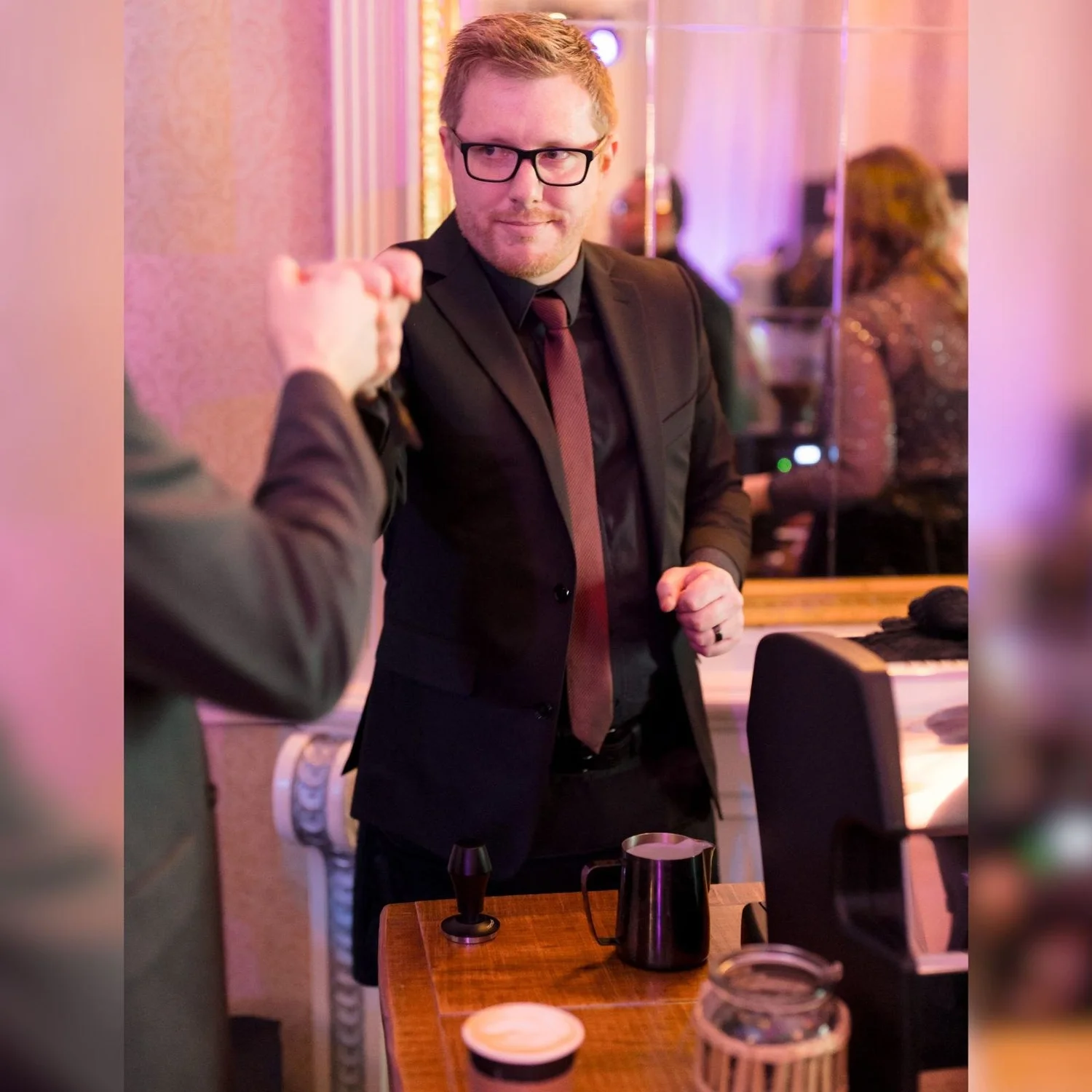 Barista smiling as he hands a guest a drink at a New Year's Eve gala