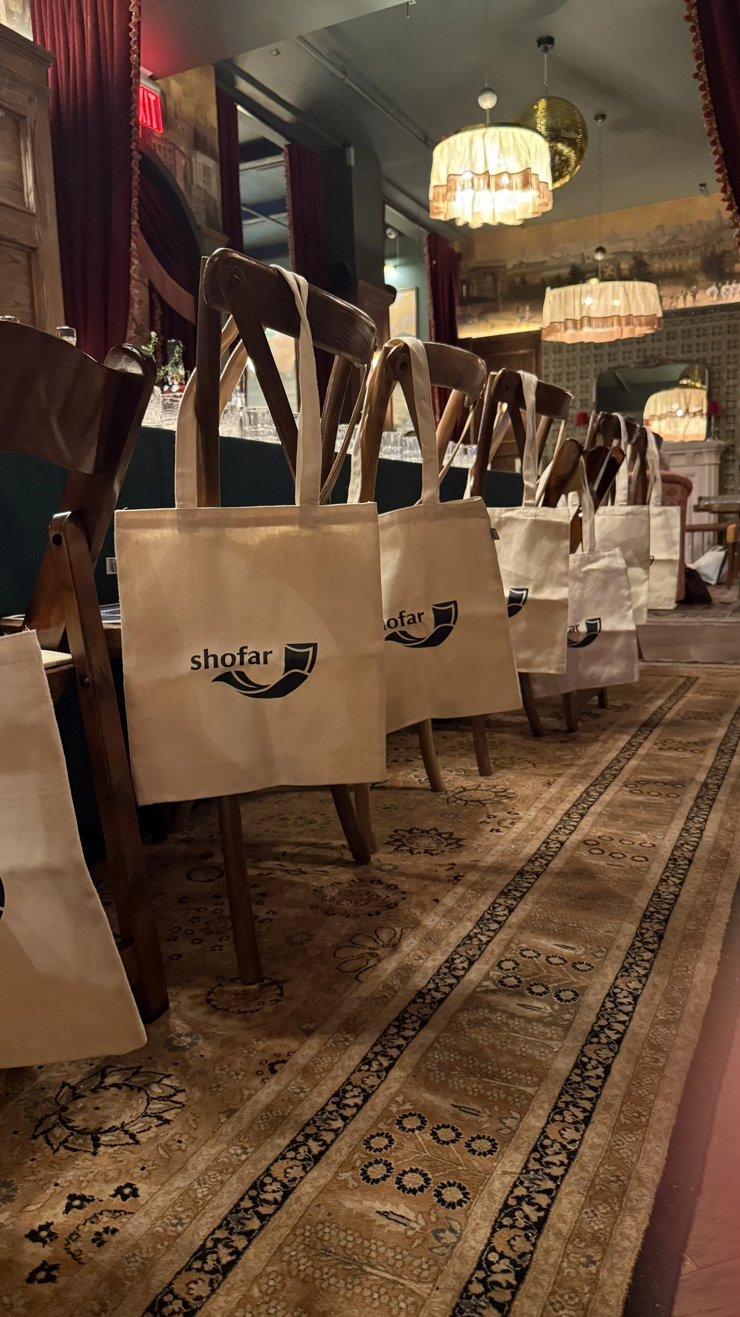 Shofar tote bags on chairs at a private gathering