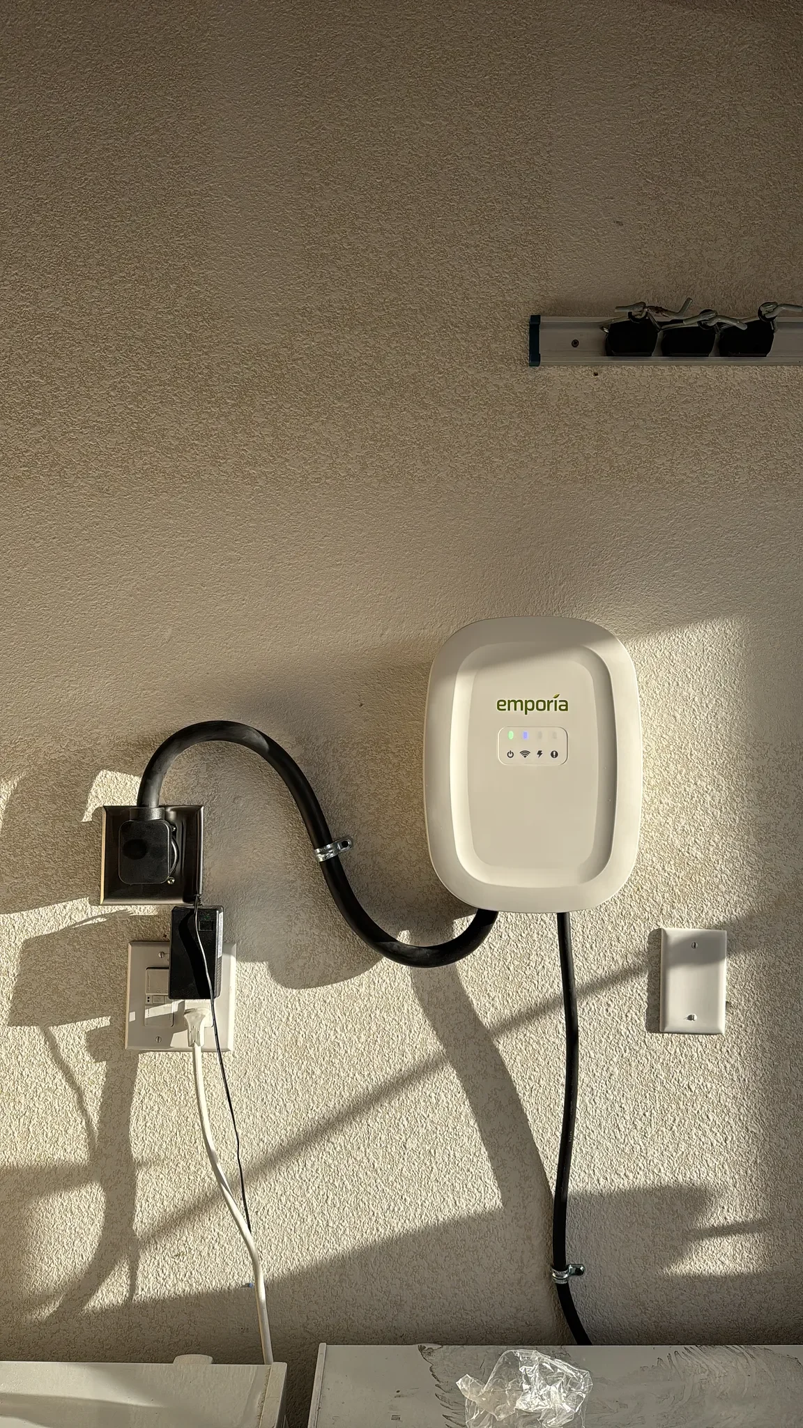 Emporia charger installed in garage beside the electrical panel