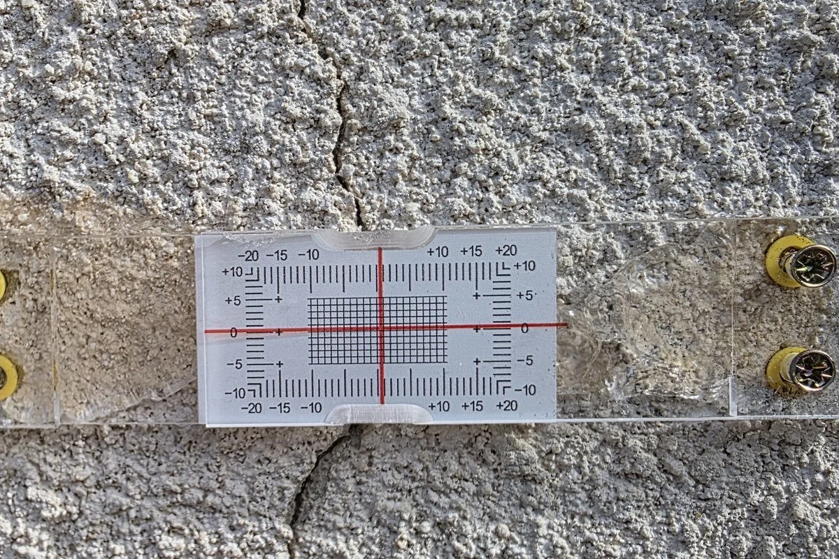 Jauge témoin vissée de part et d&rsquo;autre d&rsquo;une fissure de façade