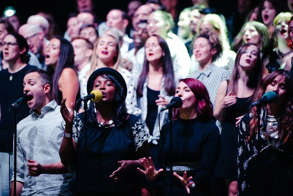 Des chanteurs réunis sur scène autour des micros