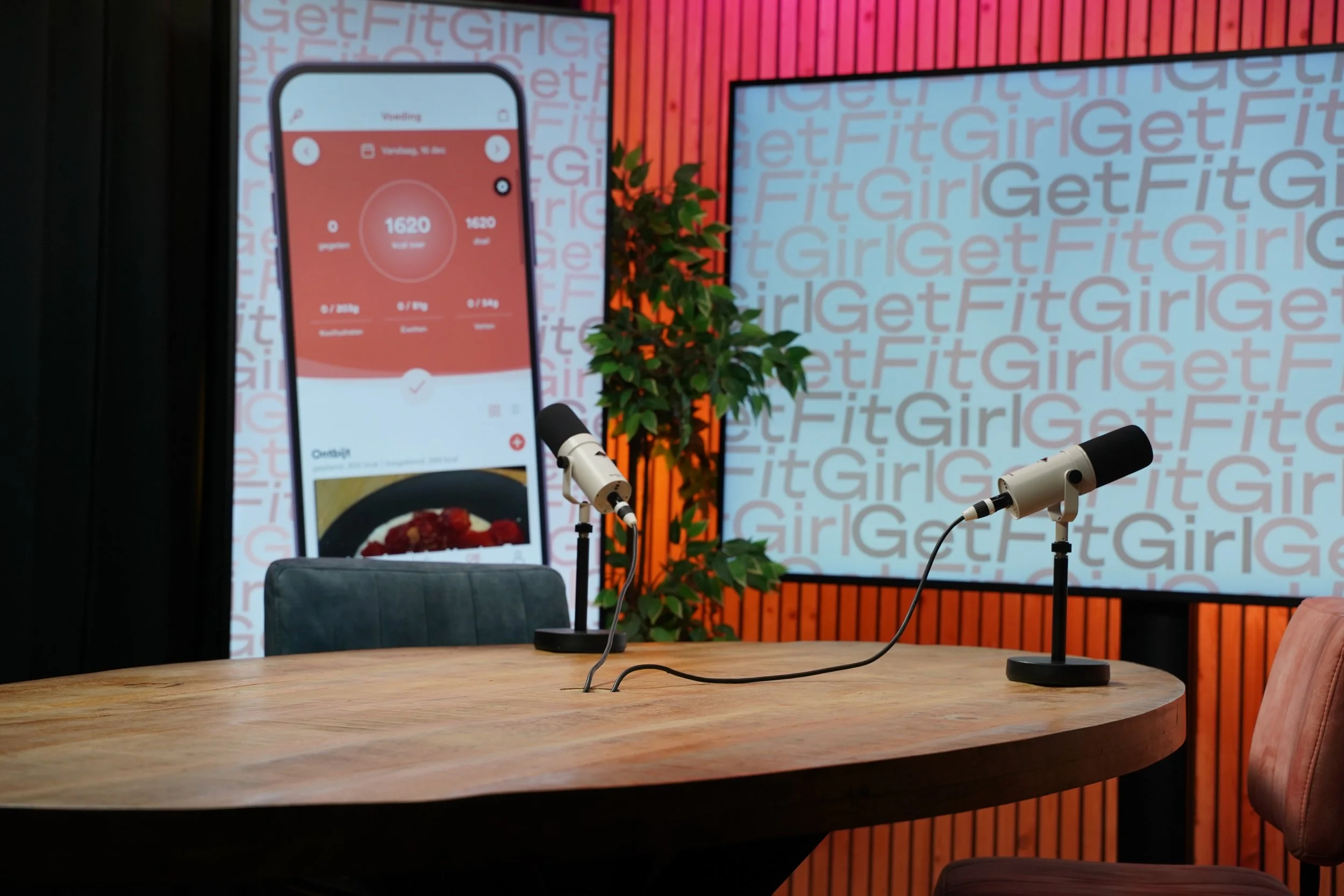 Studioverlichting met softboxen en akoestische plafondpanelen boven de podcasttafel