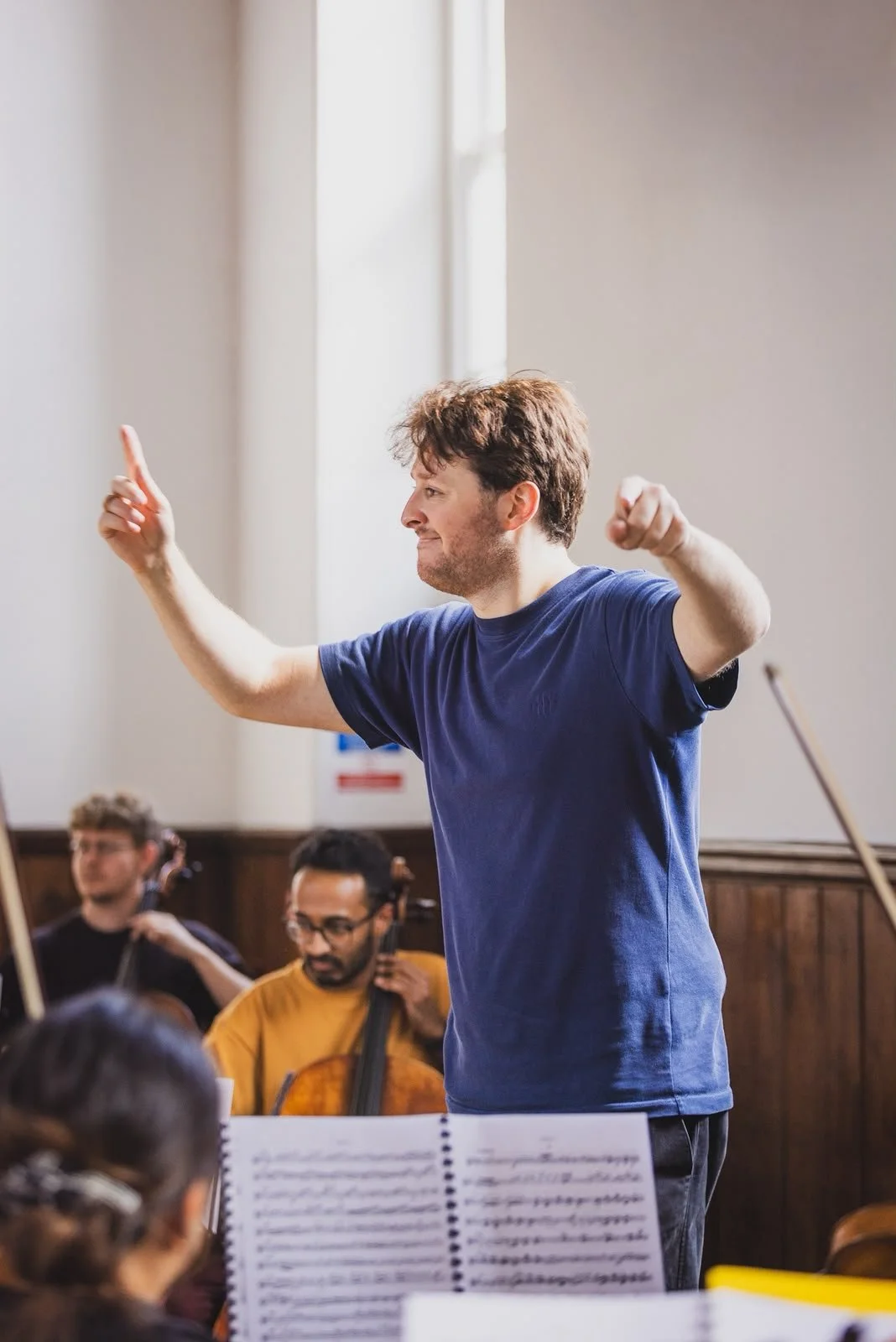 Conductor guiding the orchestra in rehearsal