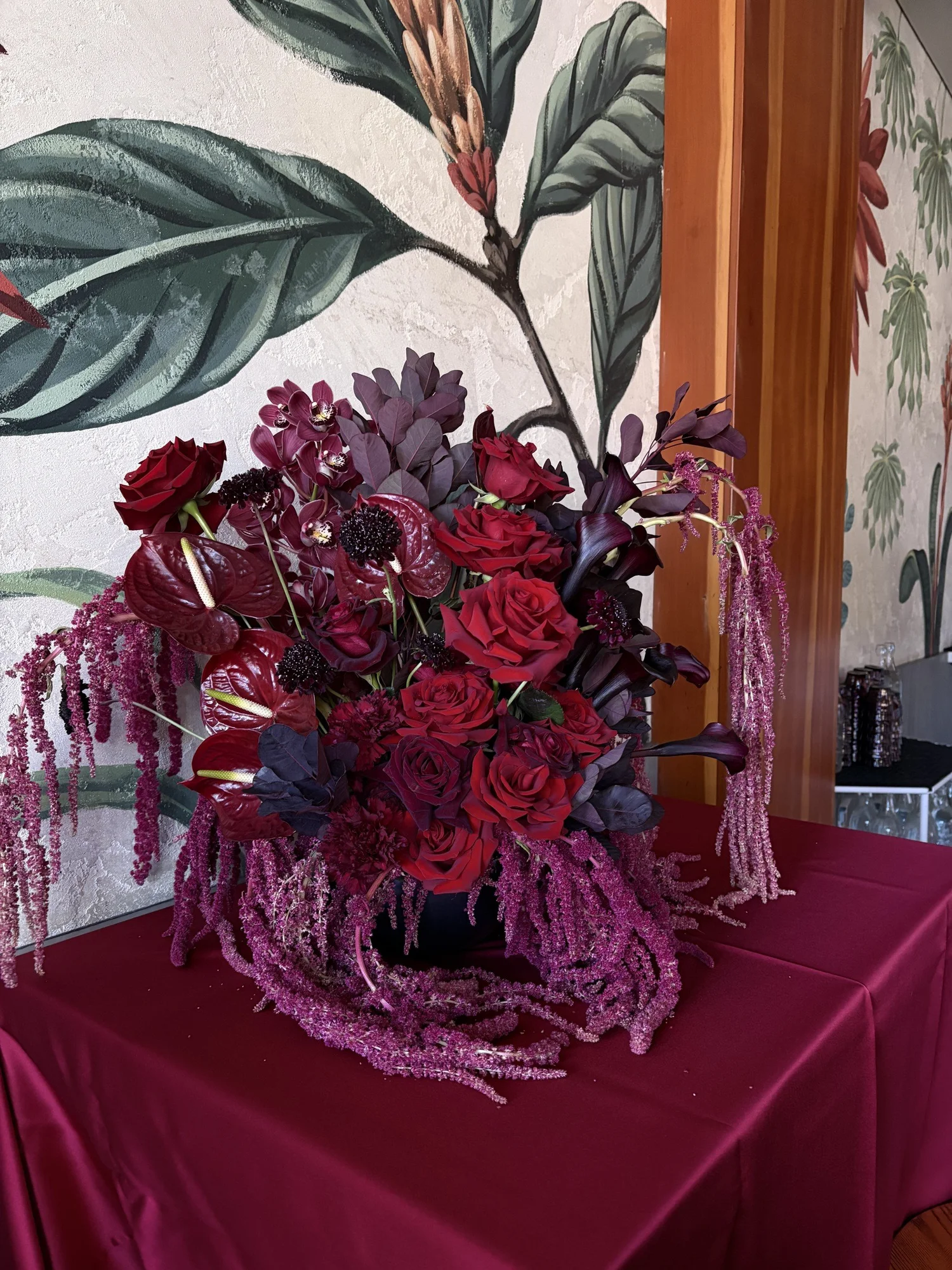 Red roses and amaranthus on a burgundy event table