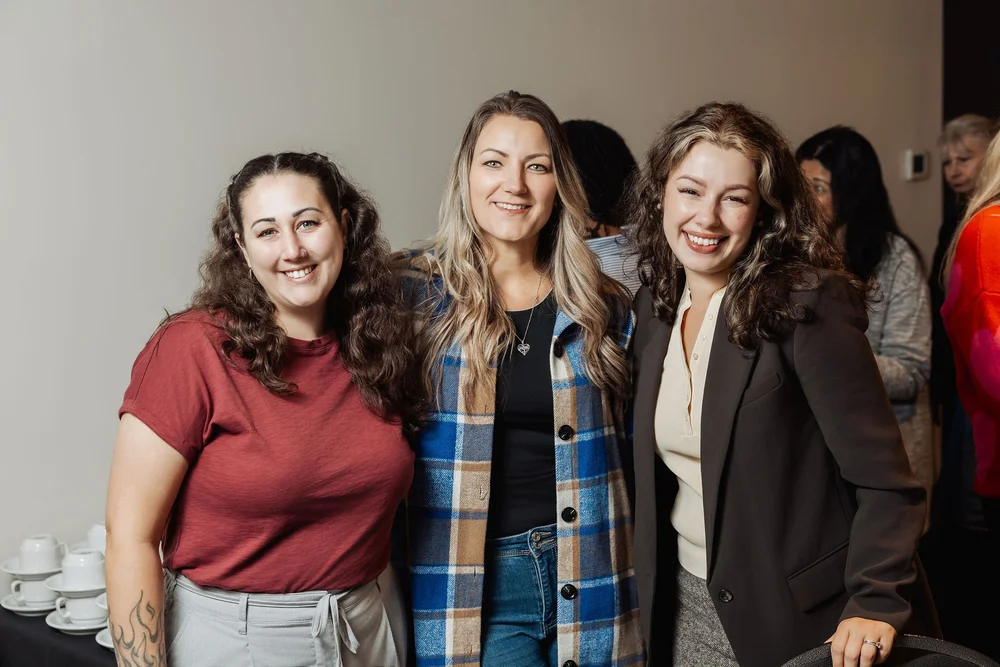 Three women smiling together at a Female Forward gathering