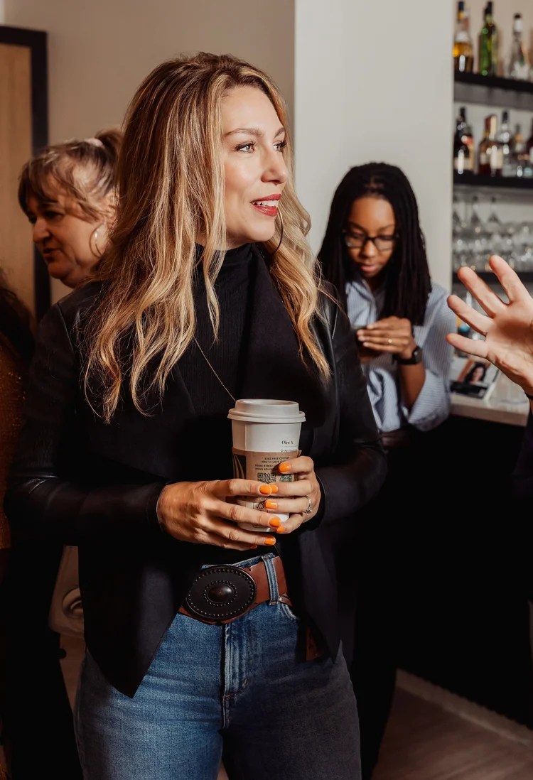 Woman arriving with coffee at a Female Forward breakfast