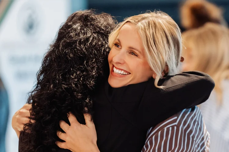 Two women hugging at a Female Forward breakfast in the Tri-Cities