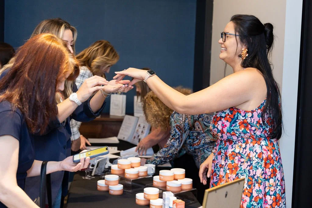 Jasmine J. of Dripped Labs sharing her products with guests at her vendor table