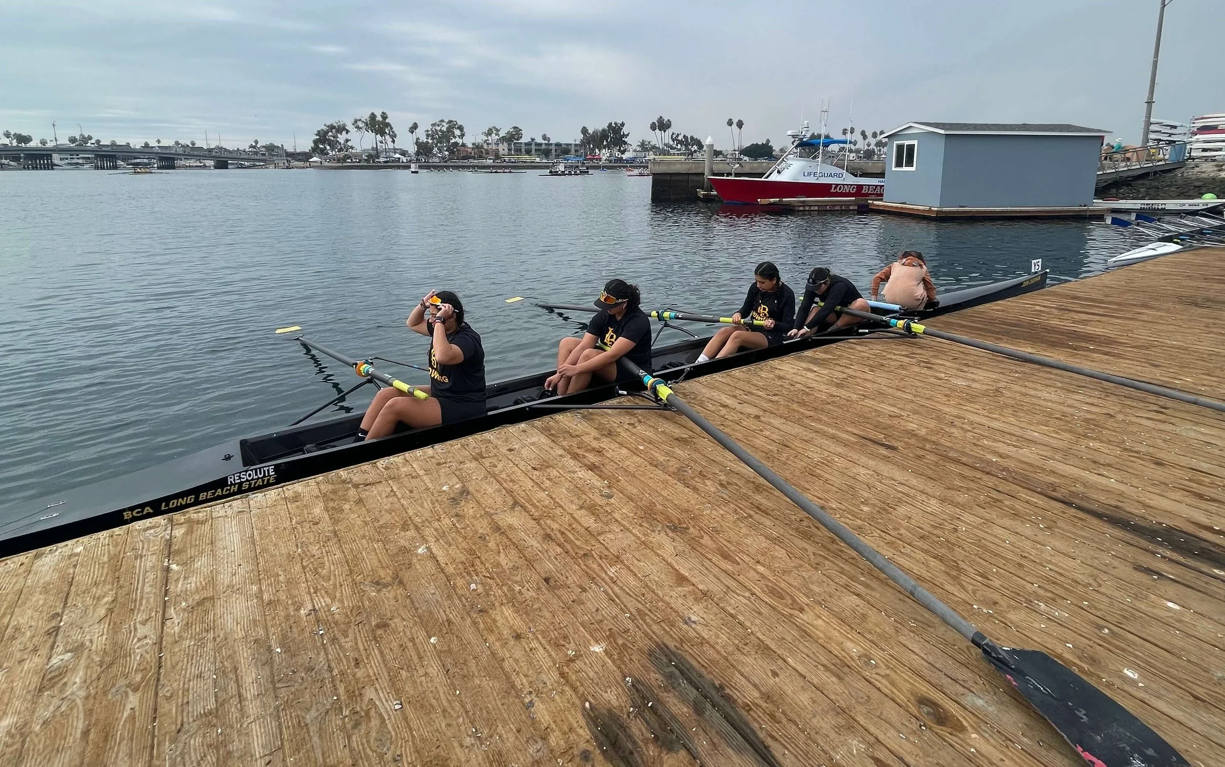 The women's varsity four prepare to launch.