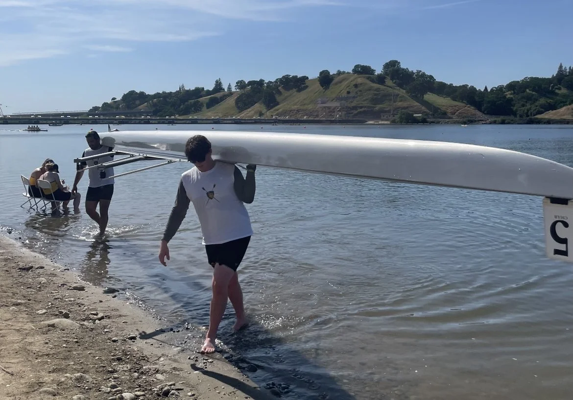 The Varsity B boat, Andres (bow) and Anthony(stroke), walk off the water after their last race.