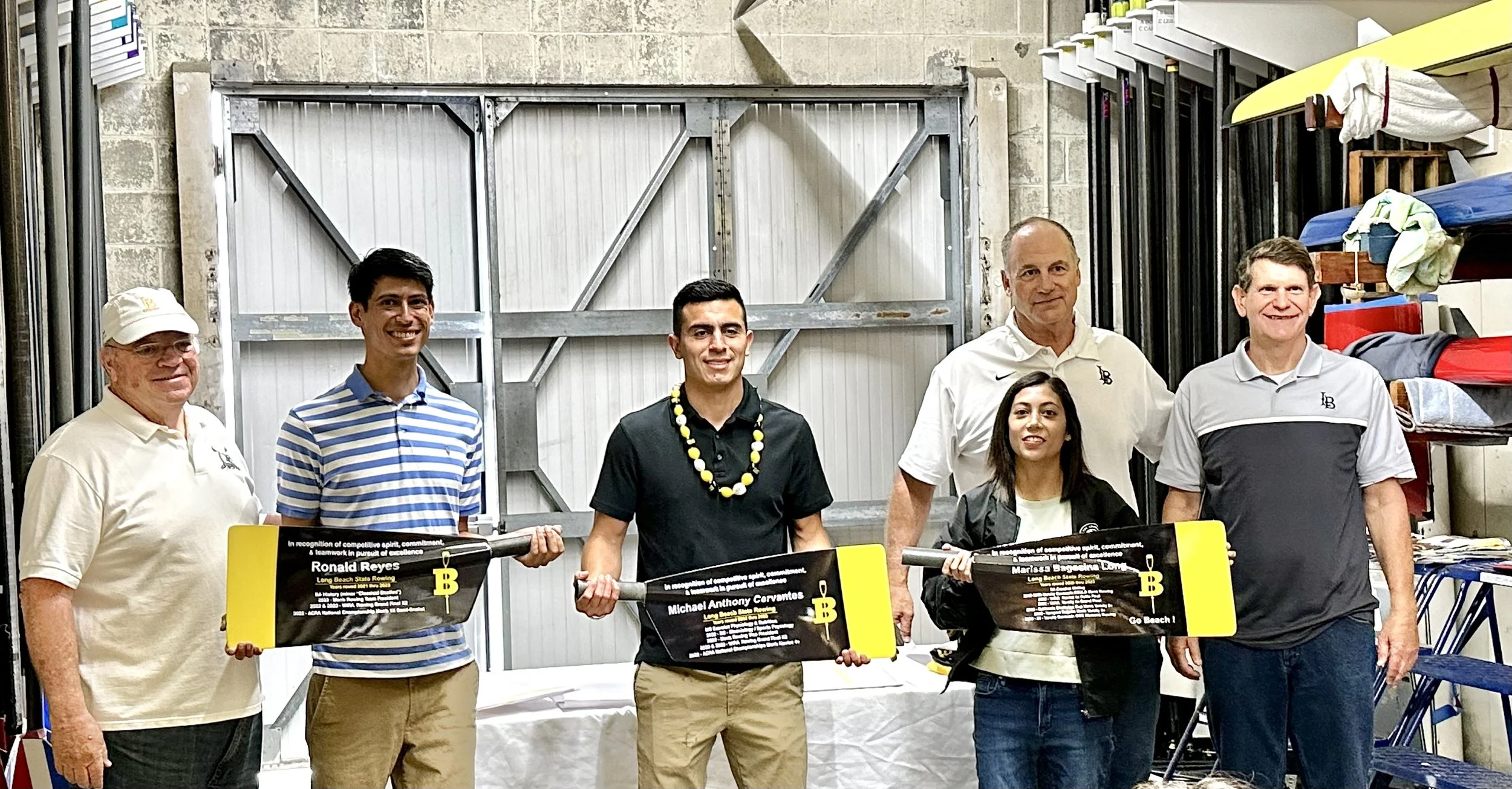 Leaving members (from left to right), varsity rower Ron Reyes-DiTraglia, varsity rower Mike Cervantes and varsity coxswain Marissa Long pose with their oars and coaches.