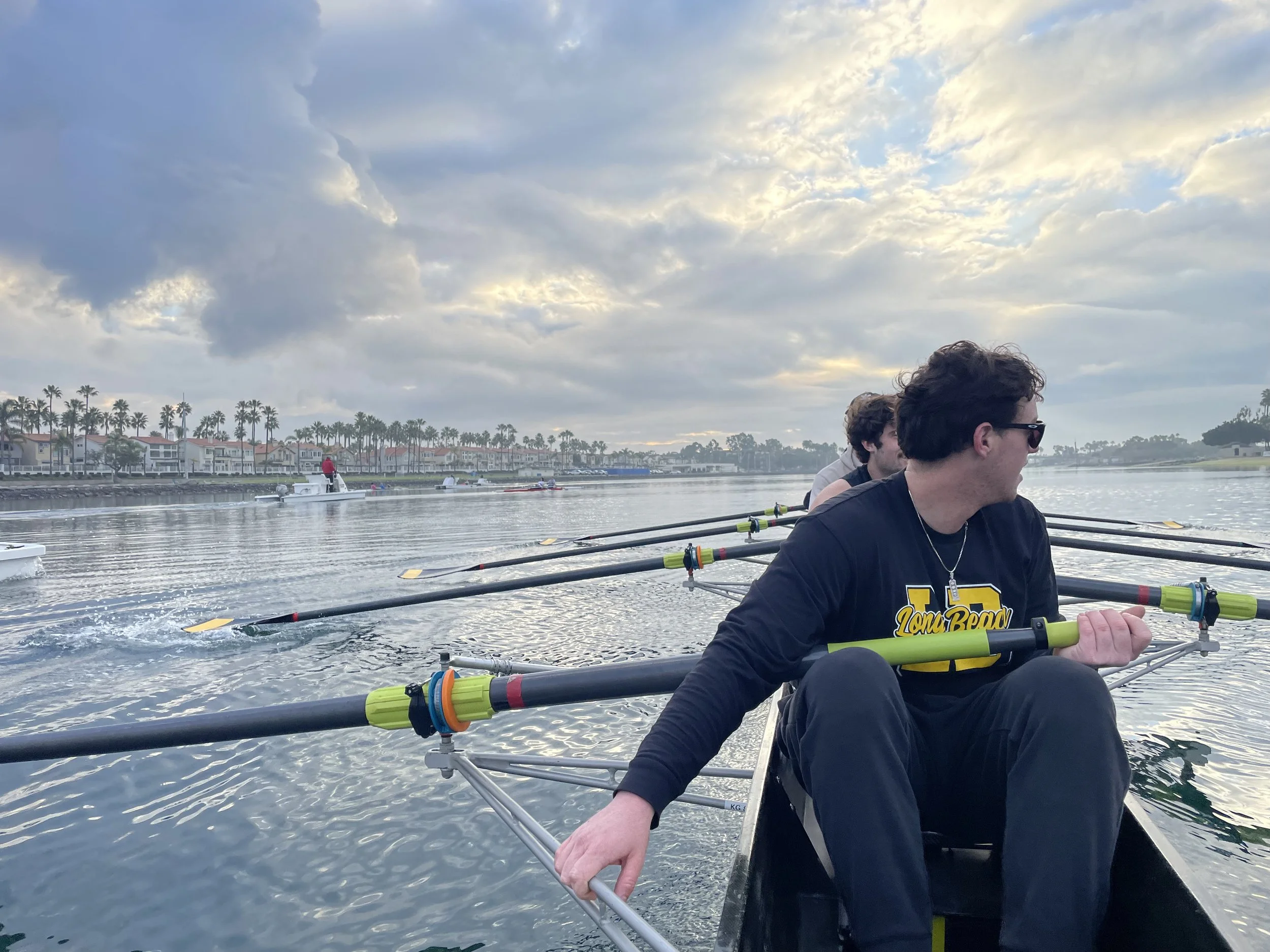 The Men's Varsity Eight with the Women's double rowing past them.