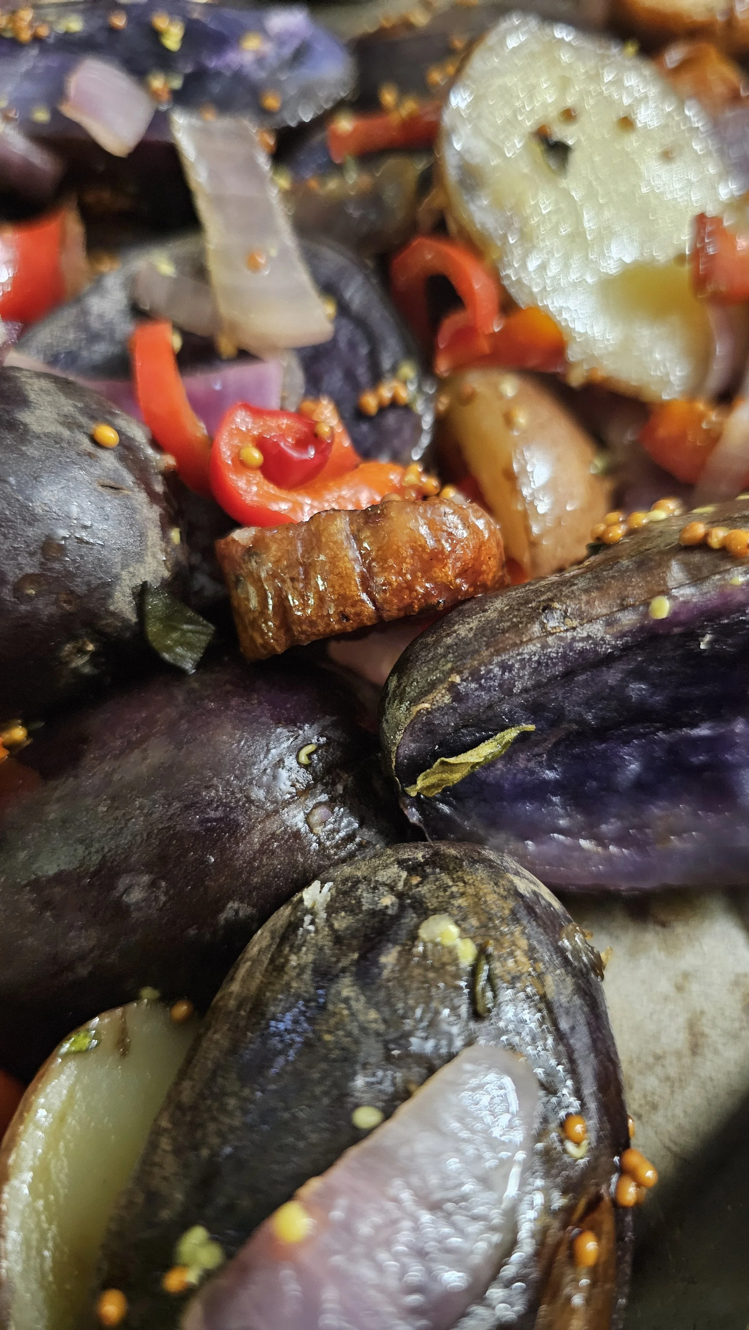 A close-up of the roasted chicken sausage and vegetables in a serving bowl