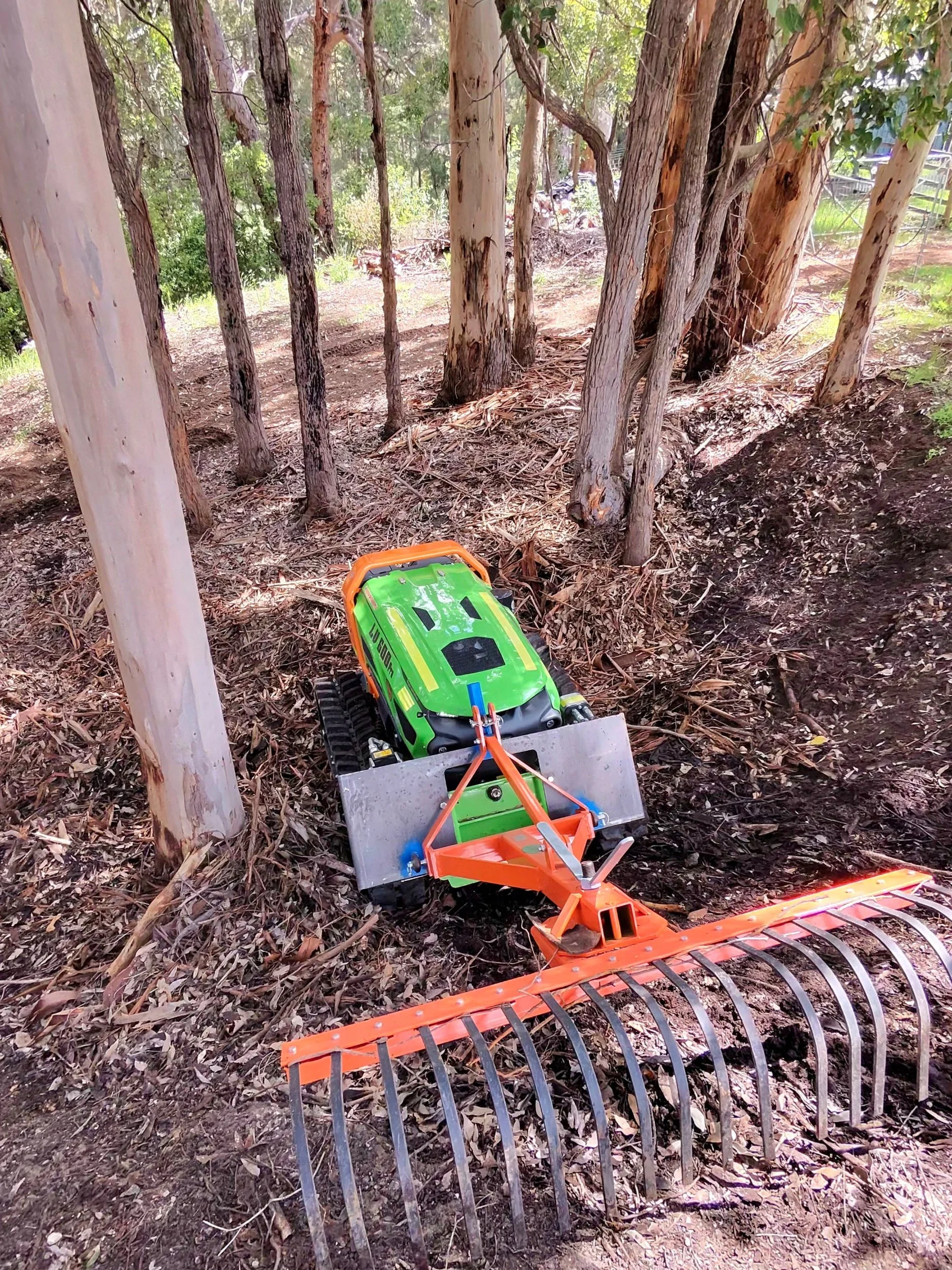 ARC11 remote-controlled machine with rake attachment working under mature gum trees, Great Southern WA