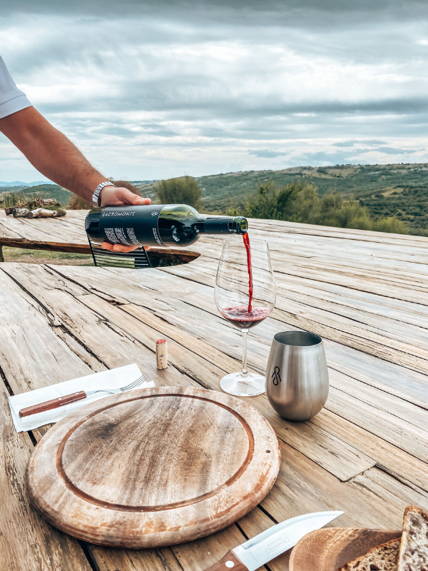 A glass of Chianti Classico on a rustic wooden table with pecorino in the background