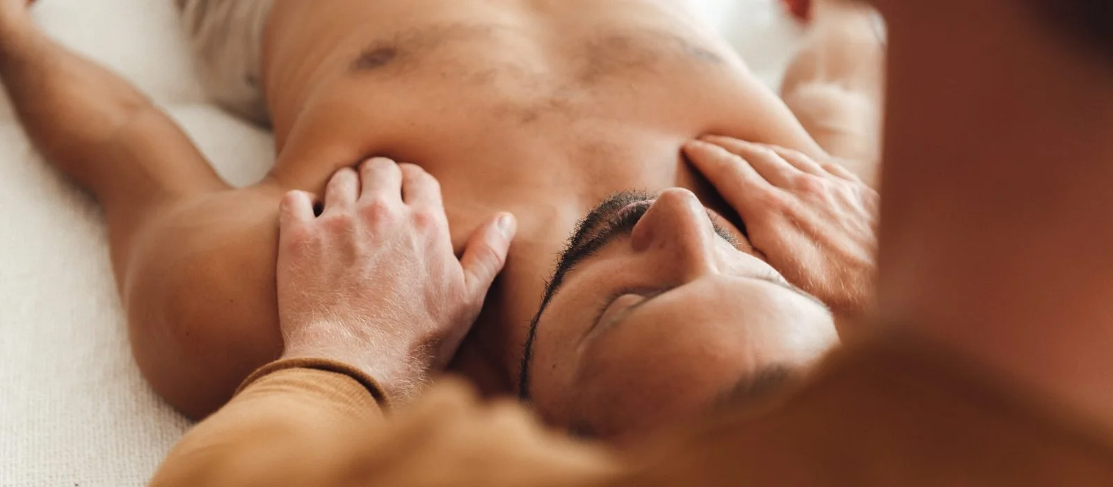 Attuned hand holding during a somatic integration session in Berlin