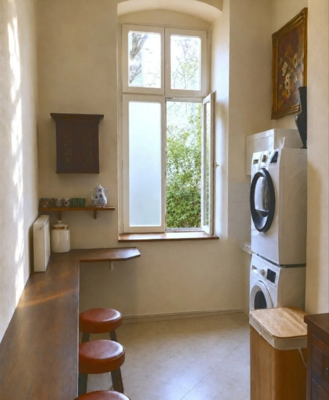 Communal kitchen with a window onto greenery, washing machine and dryer