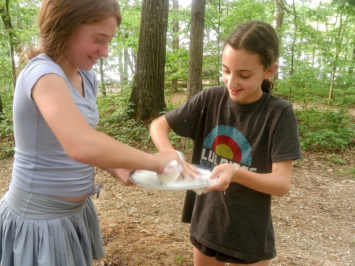 Two cohort members washing dishes together at the Shabbaton