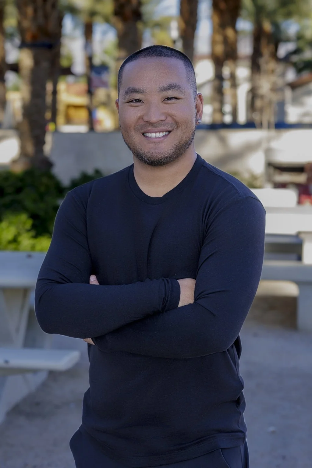 DJ Washburn smiling in a black long sleeve shirt outdoors