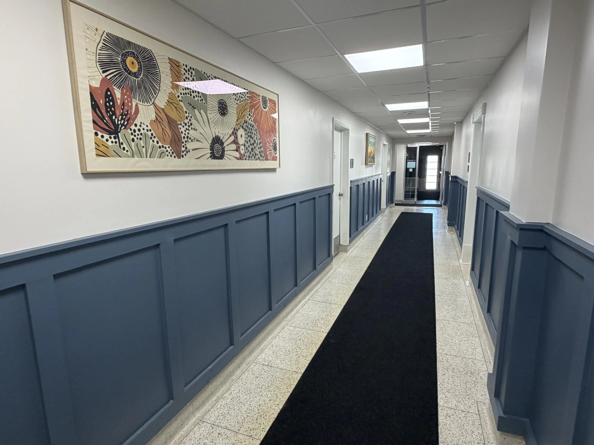 Renovated common hallway at 5579 Pearl Road with floral artwork