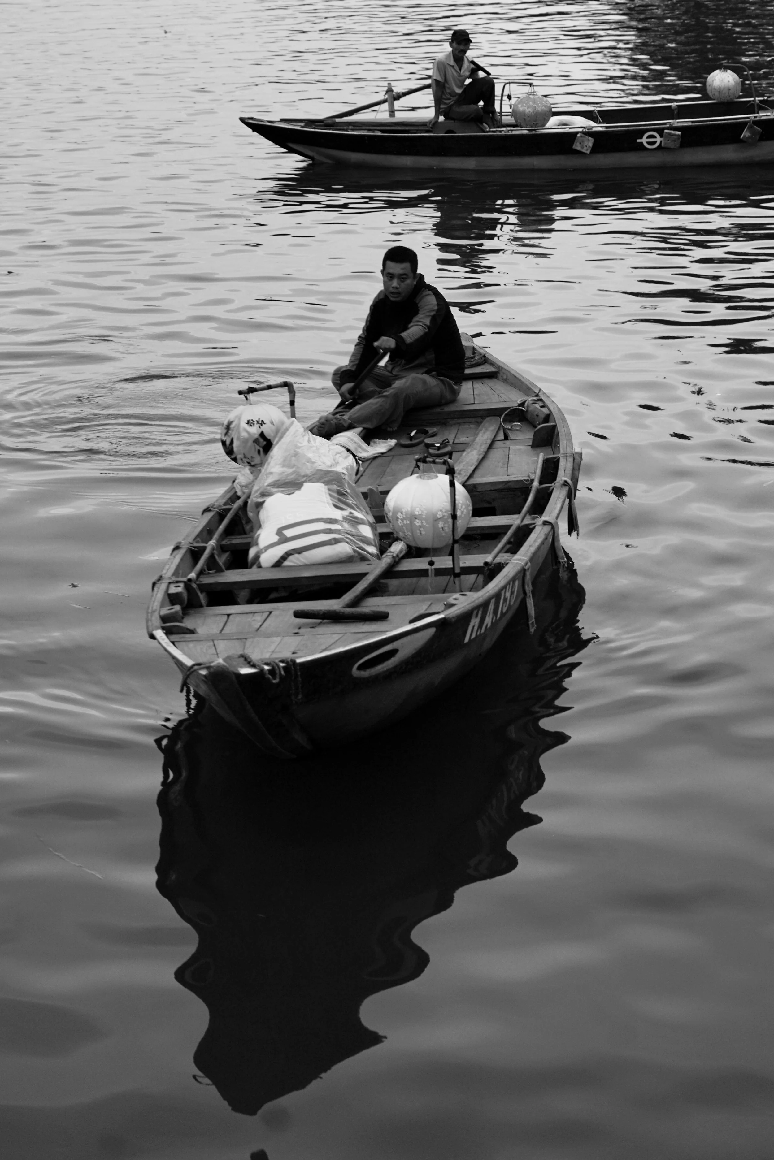 A person seated in a small boat, photograph by Frank Díaz