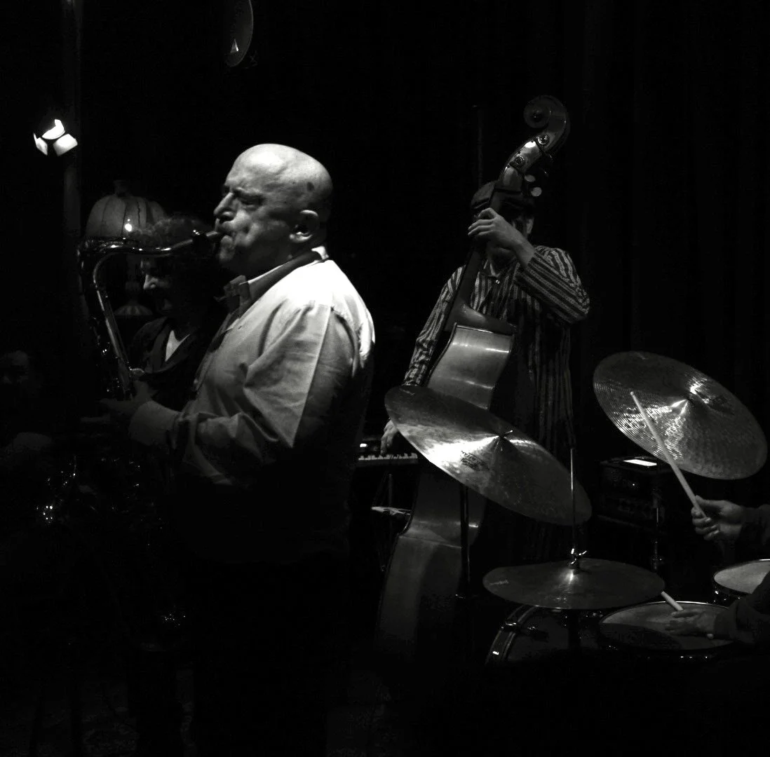 Musician performing beside a double bass, photograph by Frank Díaz