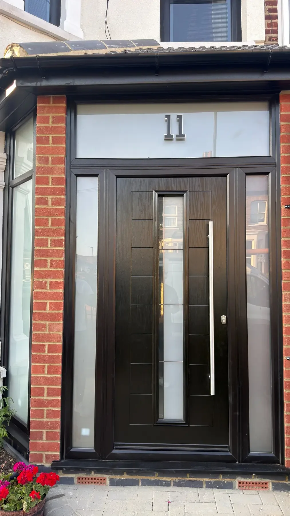 Close detail of a black composite entrance door installed by Bergmann Windows