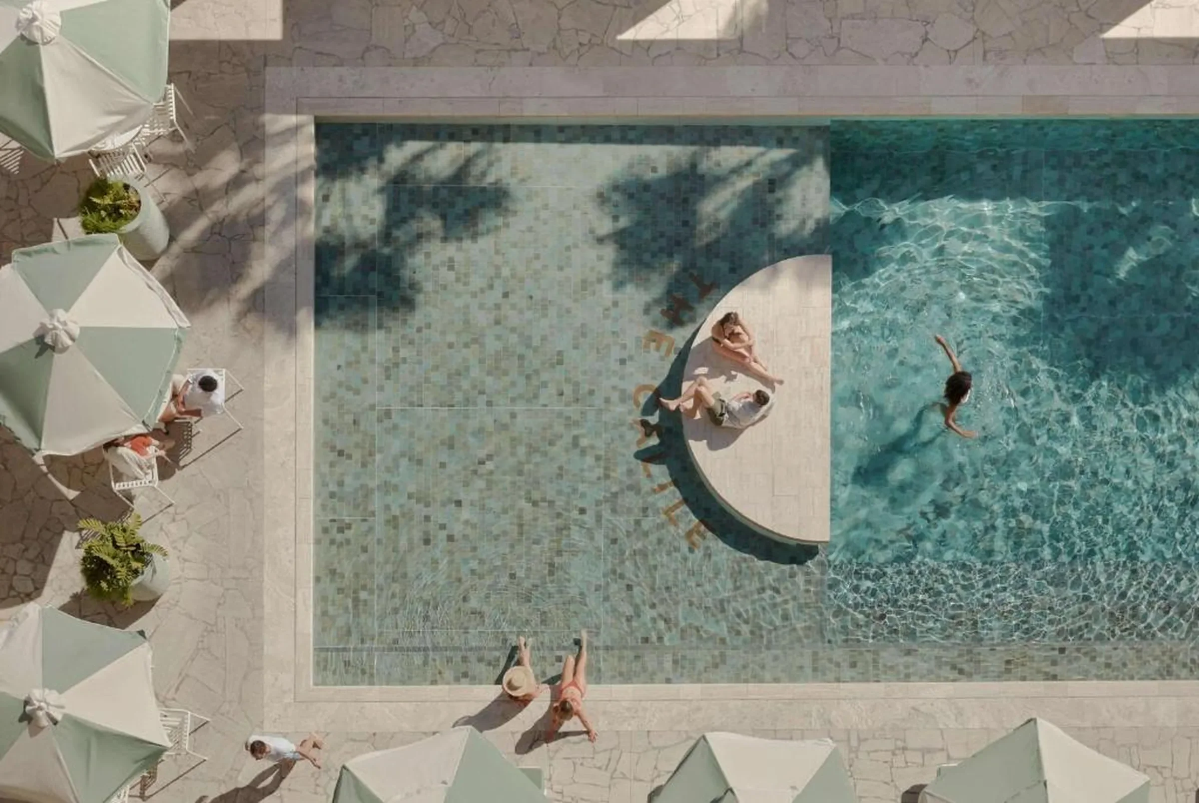 Aerial view of a resort pool and guest deck, a hospitality going concern of the kind owners refinance for retirement, an estate or a buyout