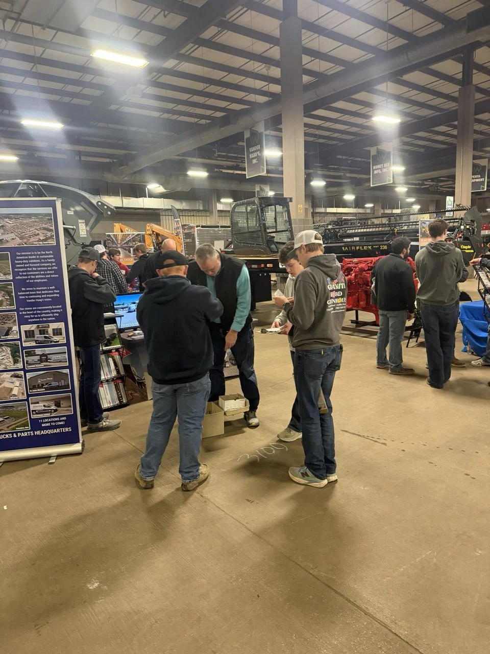 Exhibitors and growers talking at a booth on a farm show floor