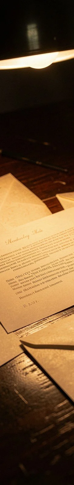 Royalty statements and envelopes under a warm desk lamp