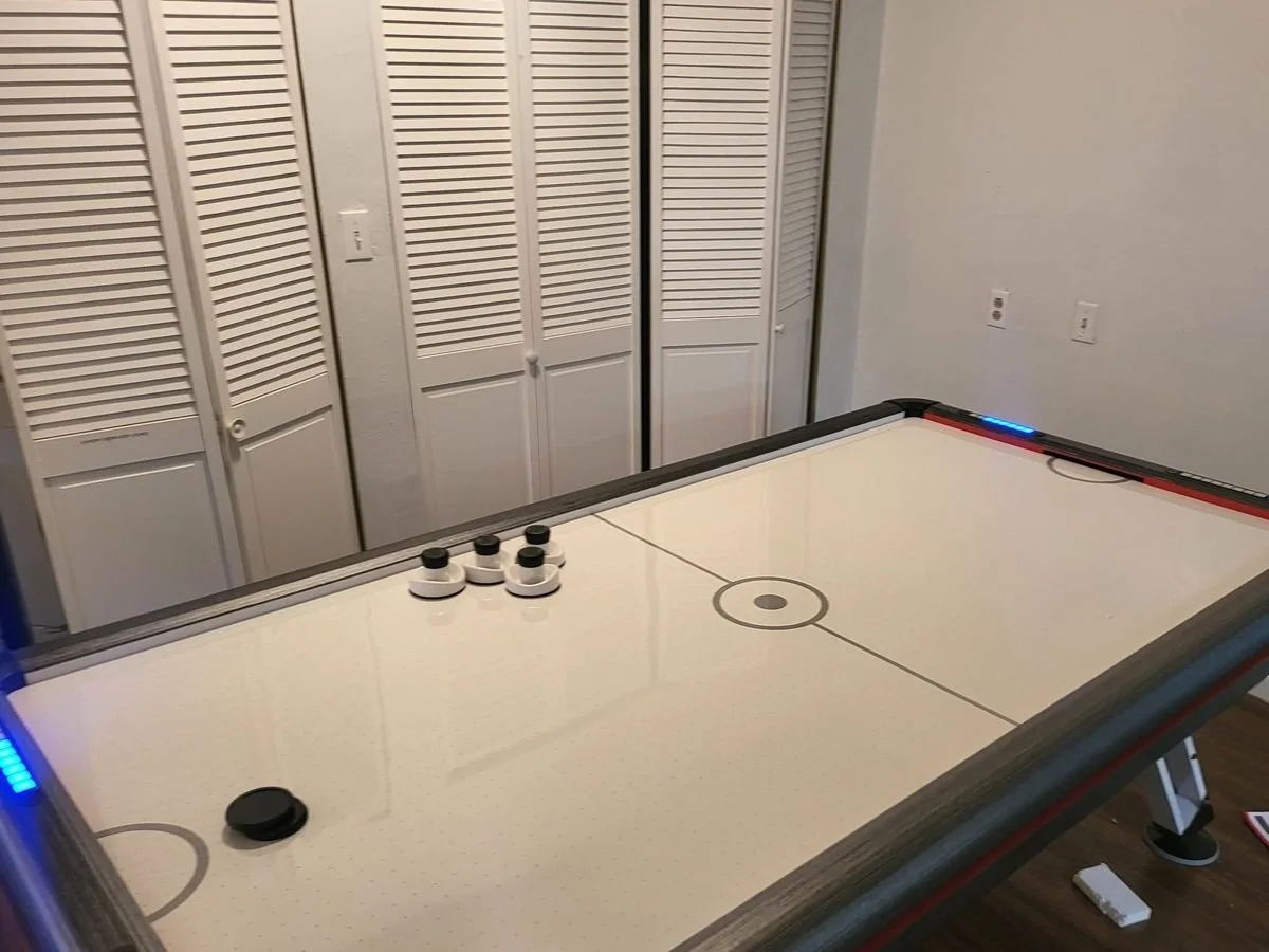 Air hockey table assembled and ready to play in a Phoenix game room