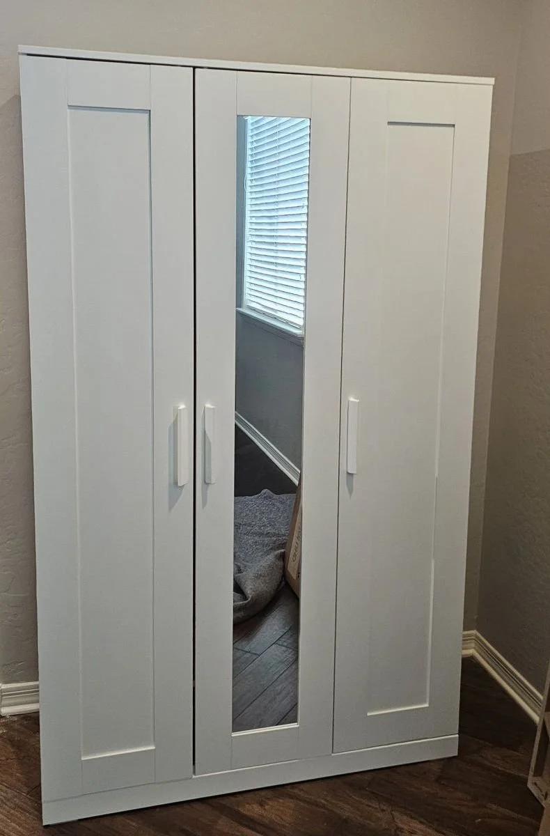White IKEA Brimnes three-door wardrobe with mirror assembled in a Phoenix bedroom