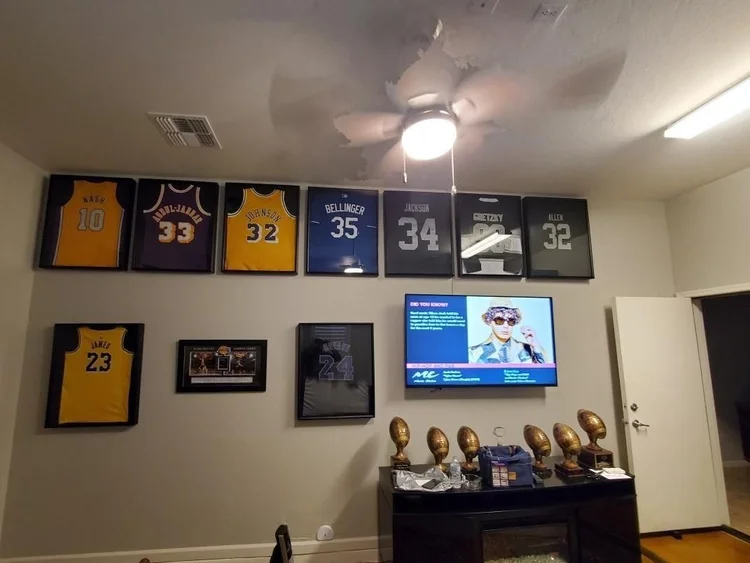 Framed sports jerseys hung and TV mounted in a Phoenix man cave