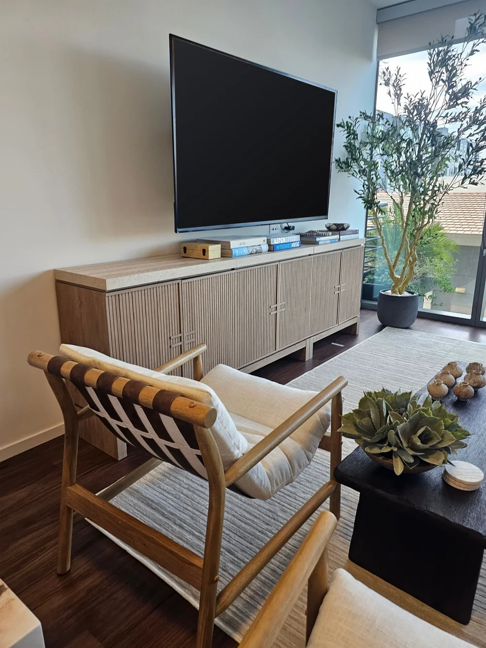 Living room set up with a TV mounted above a fluted media console in a Phoenix short-term rental