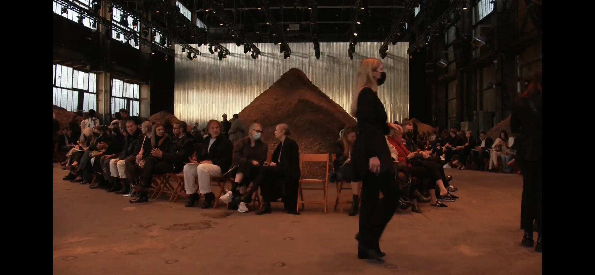 Fashion presentation with minimalist seating in an industrial venue