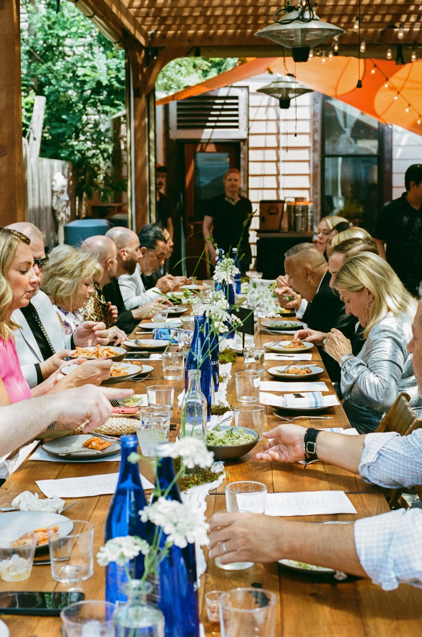 Handmade folding farm tables paired with vintage wooden folding chairs for an outdoor wedding reception at Corto Jersey City