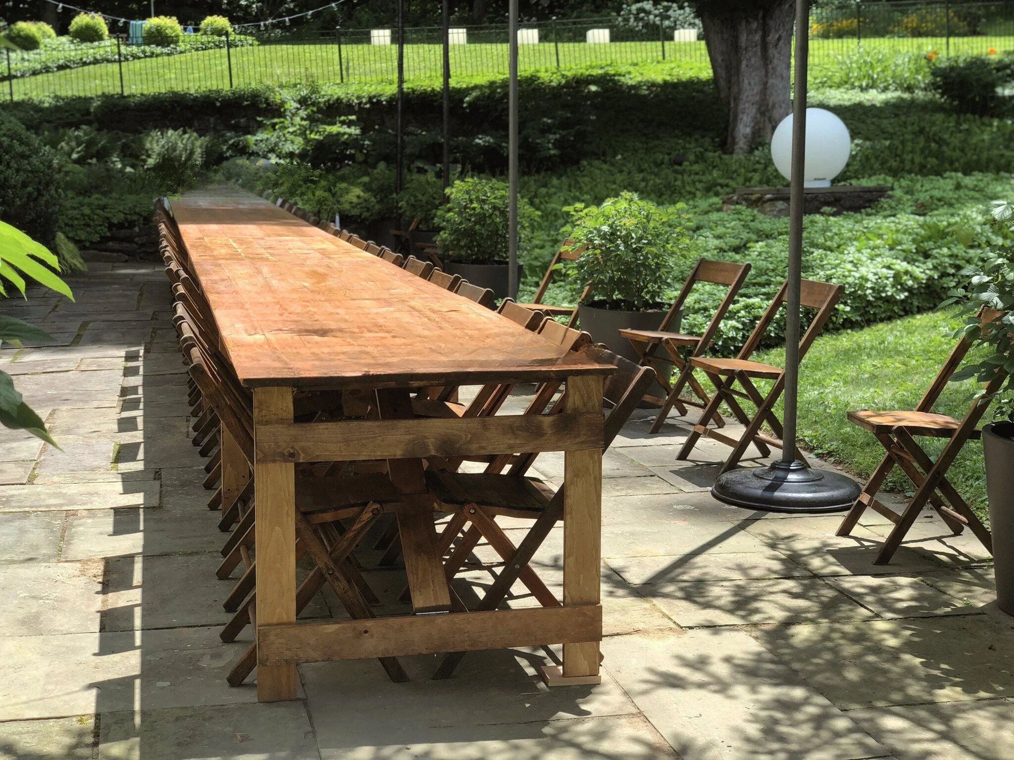 Vintage wooden folding chairs set for an outdoor garden wedding ceremony with aisle seating