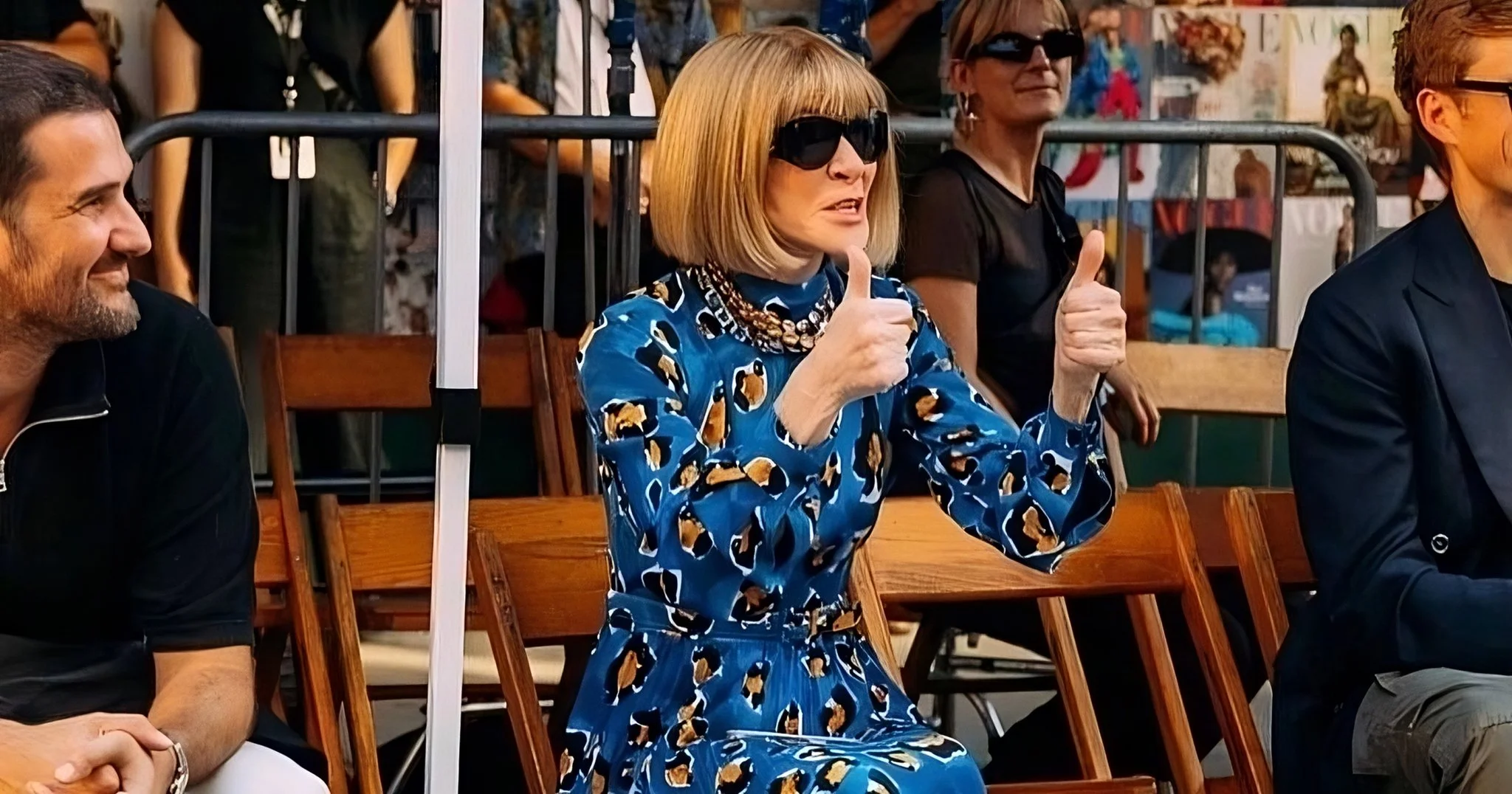 Anna Wintour seated in vintage folding chair giving two thumbs up at Vogue World 100th anniversary show