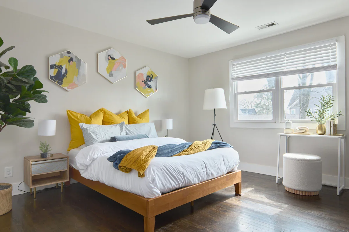Bright bedroom with yellow accent pillows and a sunny reading area