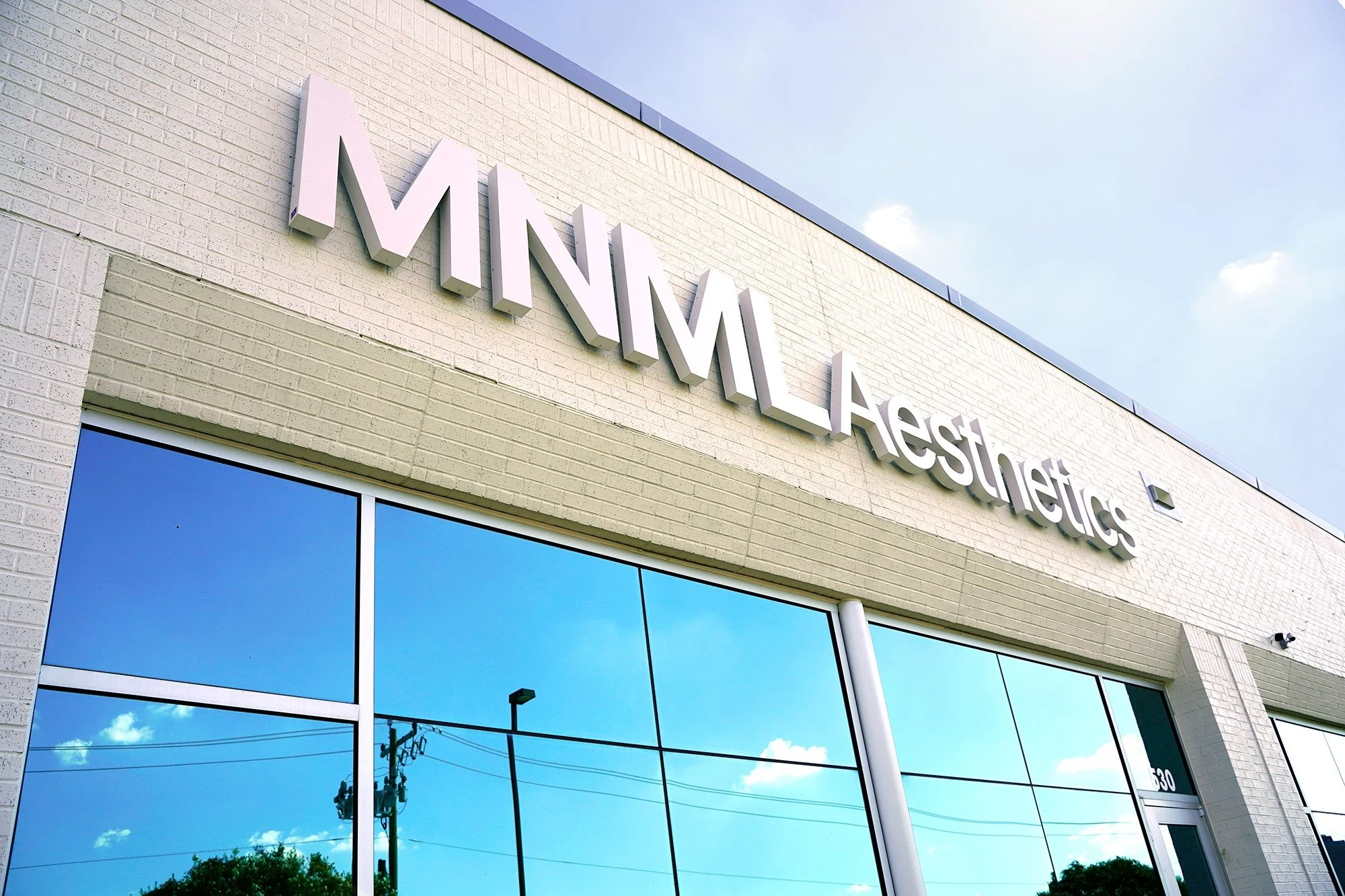 MNML Aesthetics sign above the clinic’s glass storefront