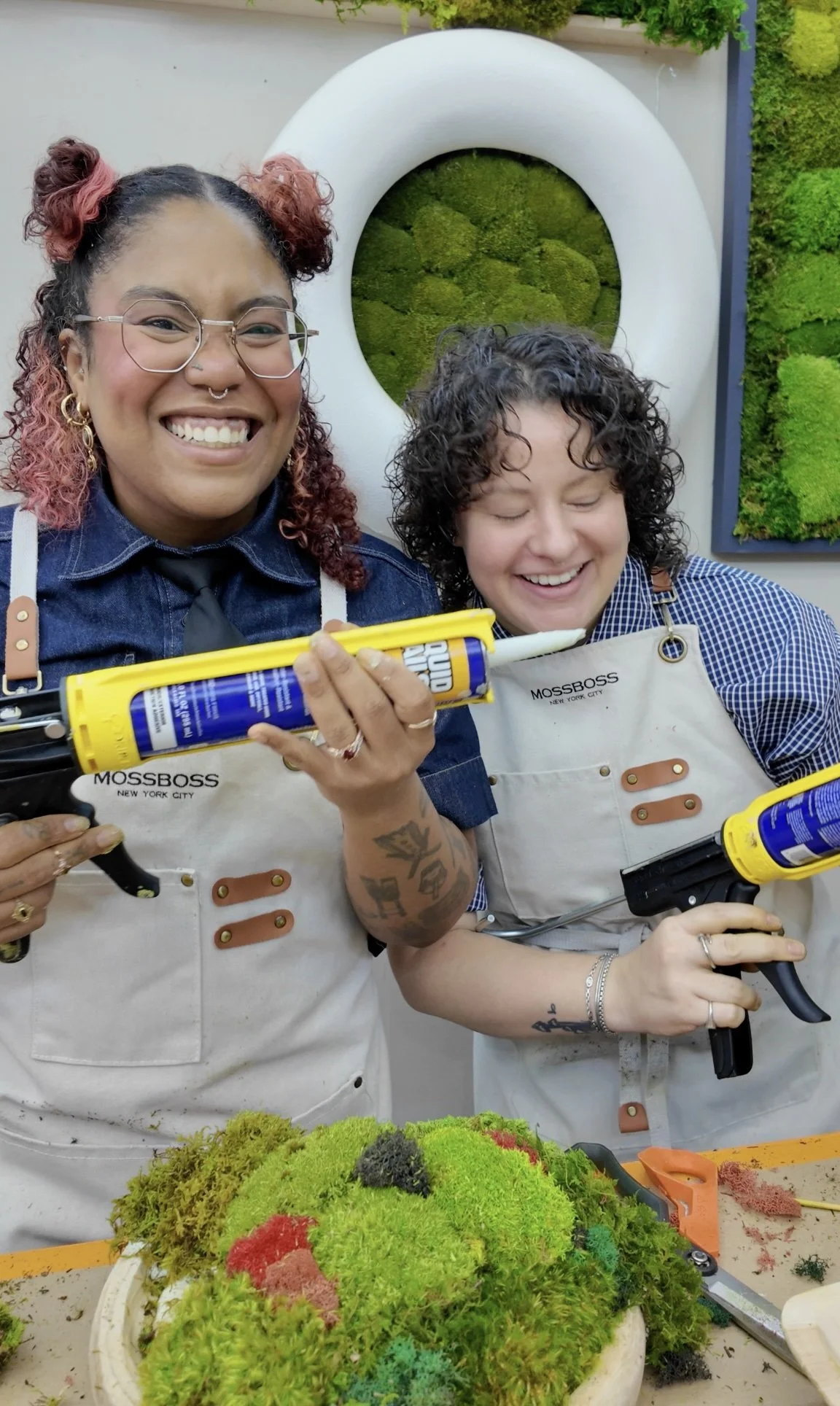 Kate and Vicky laughing with glue guns during their moss bowl class
