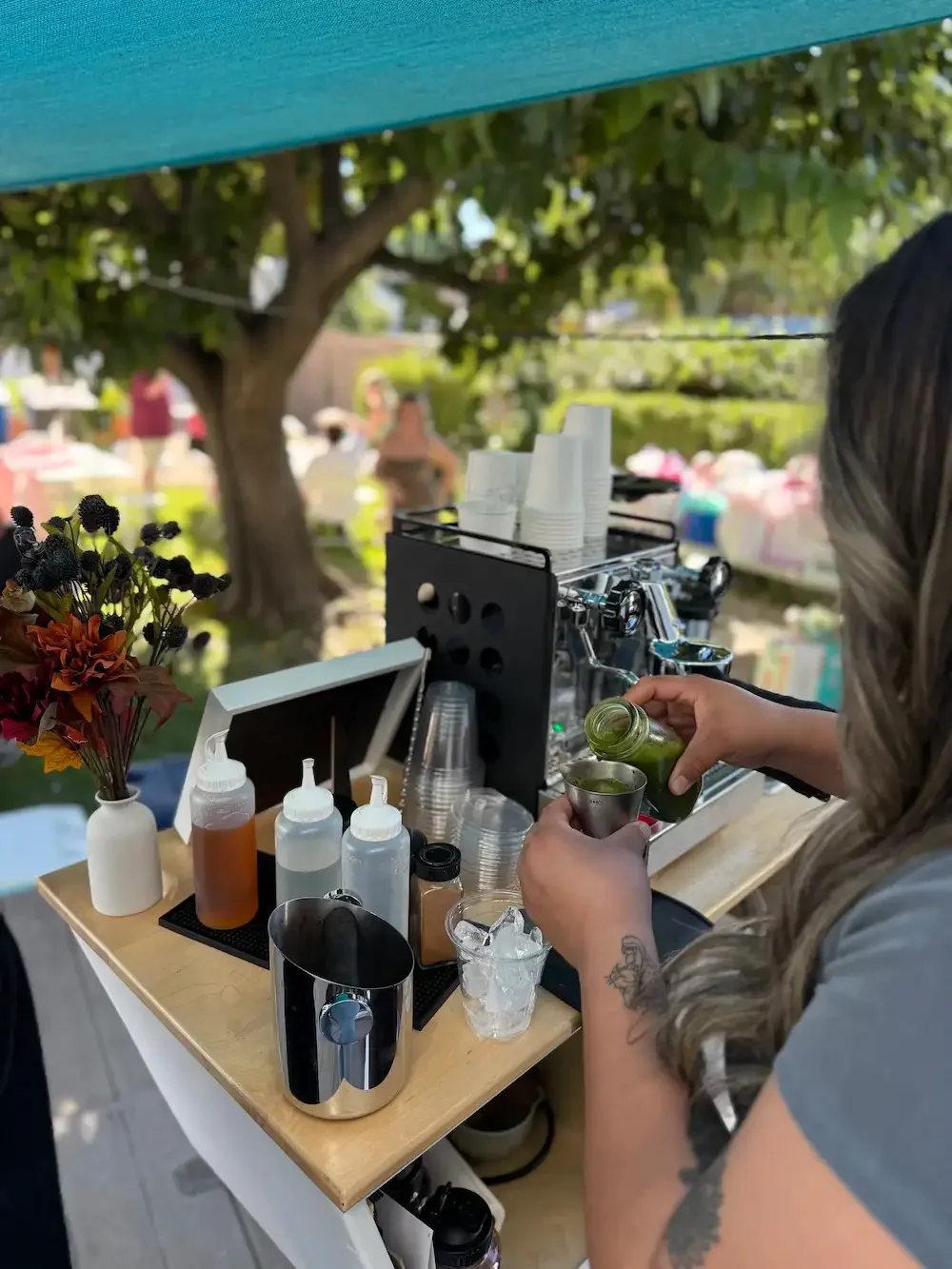 Barista pouring matcha at an outdoor mobile coffee cart in Orange County