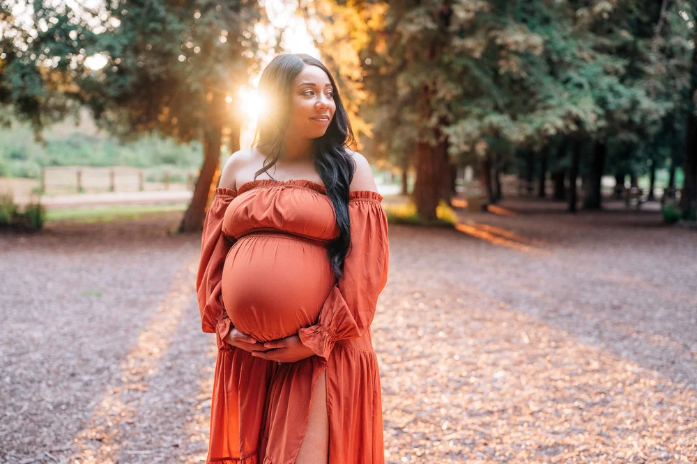 Maternity portrait outdoors at golden hour, calm and joyful
