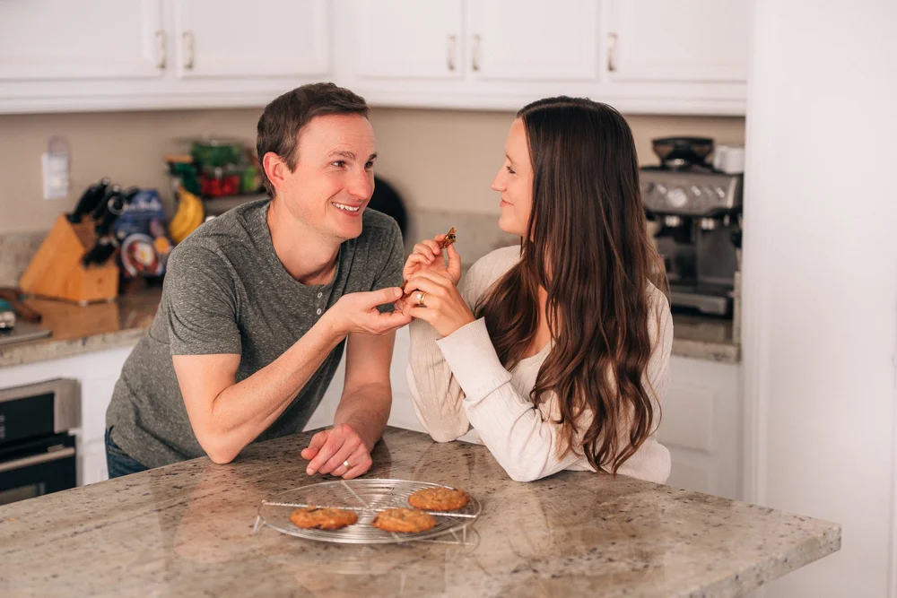 Both parents eating the cookies they just baked during an in-home session in Irvine