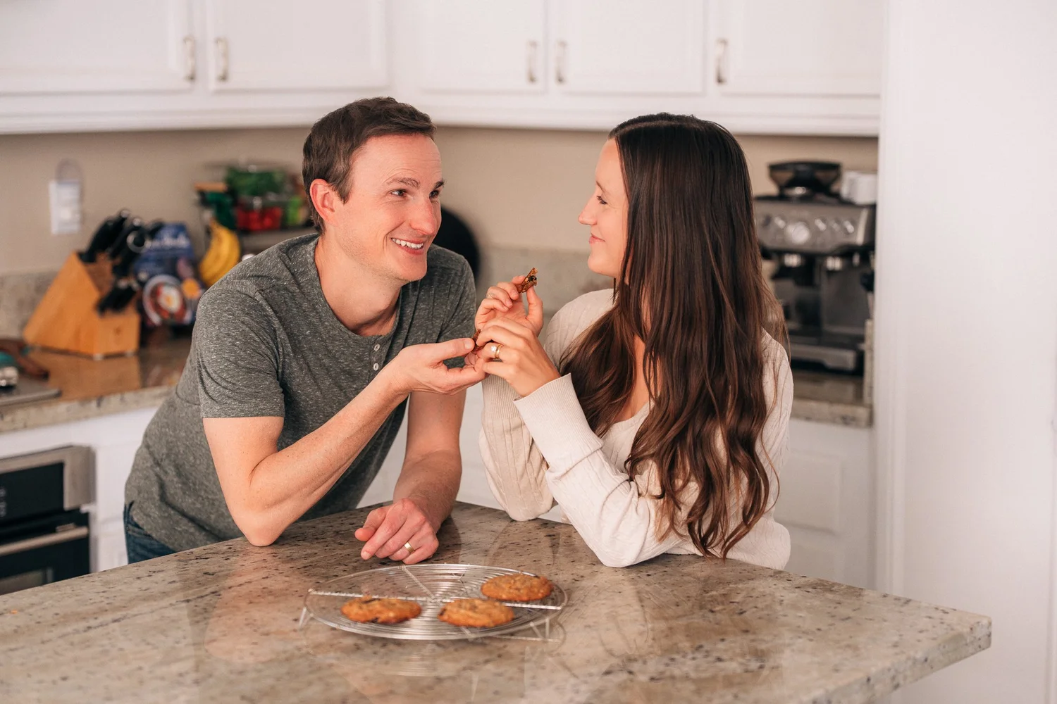 Both parents eating the cookies they just baked during an in-home session in Irvine
