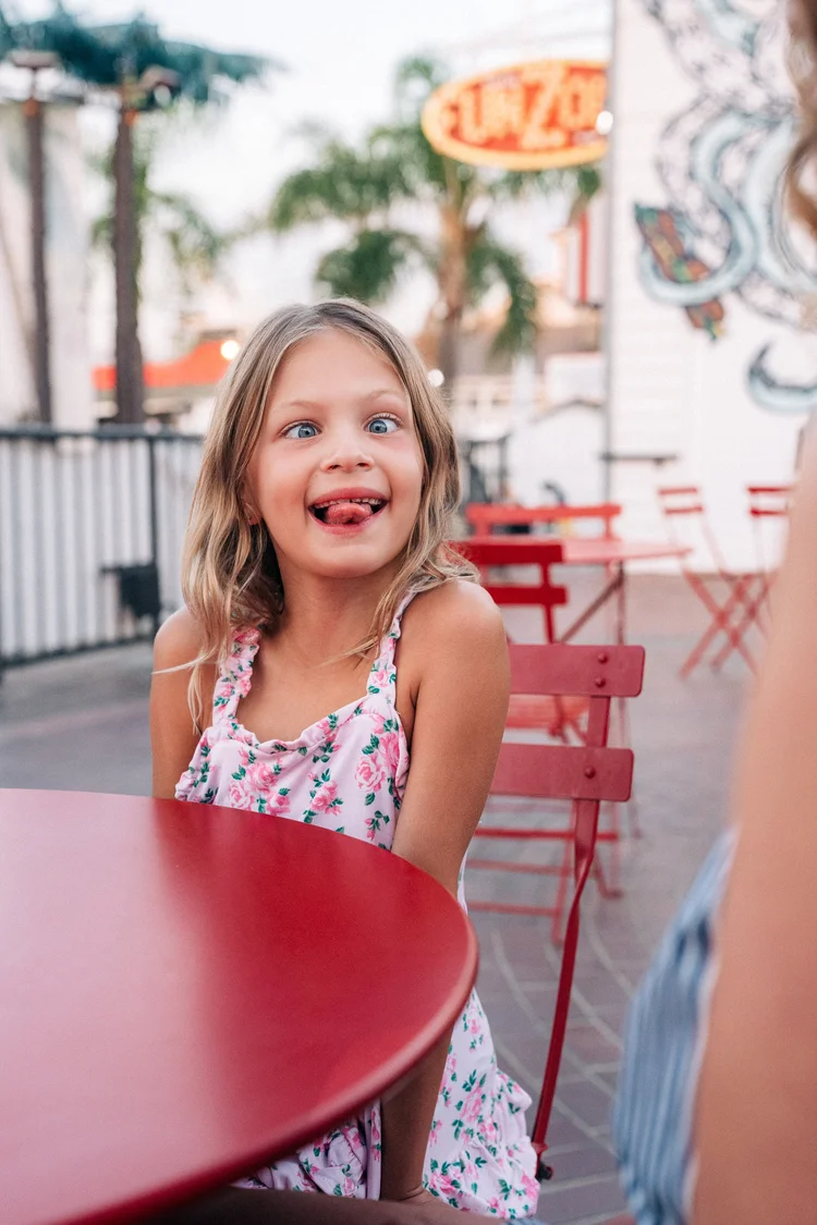 A child laughing at a cafe table during a family storytelling session