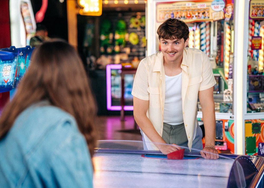 Quinn and Parker playing air hockey in the Belmont Park arcade